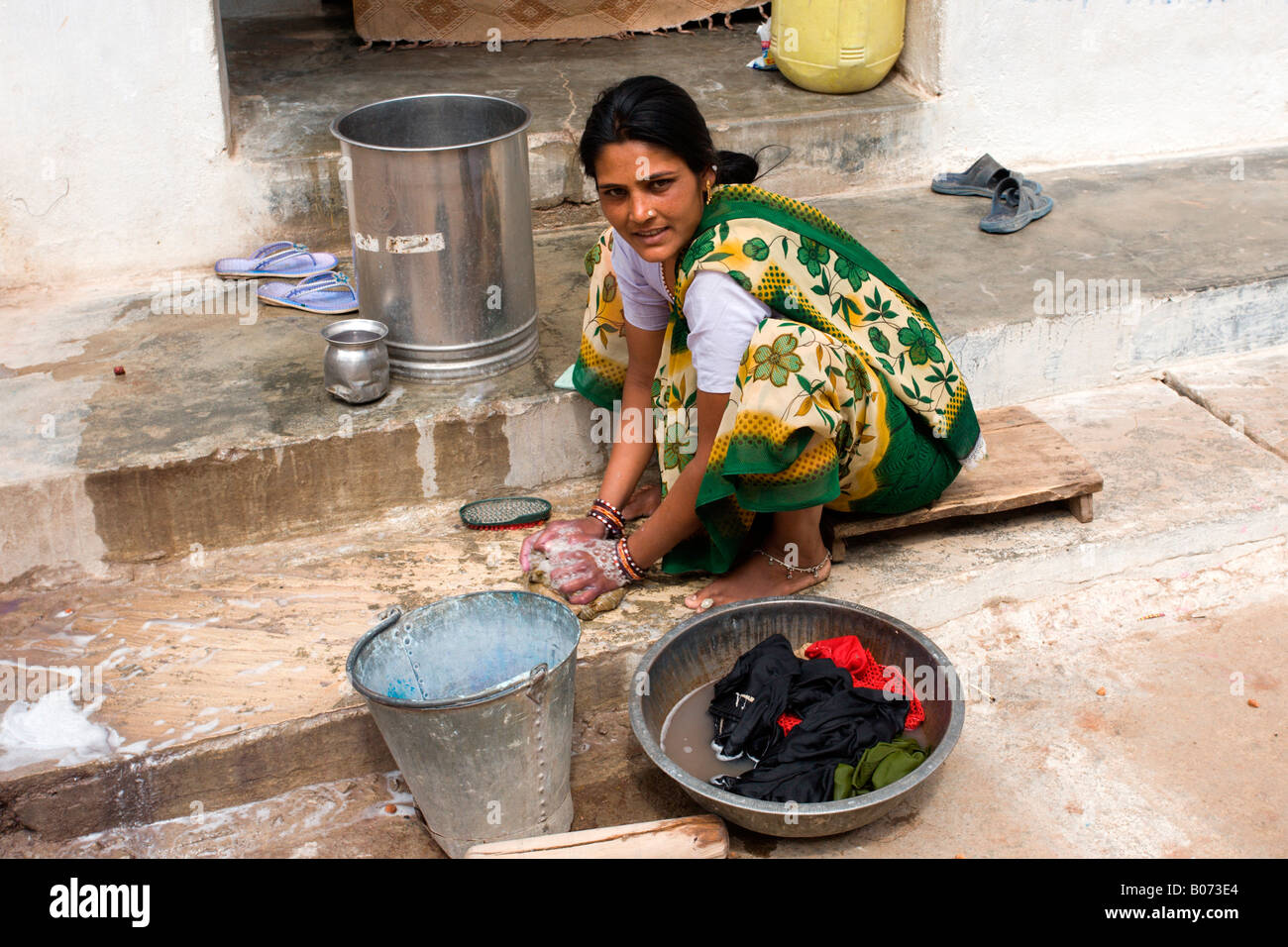 Khajuraho Dorf: Junge Dame Waschen von Kleidung Stockfoto