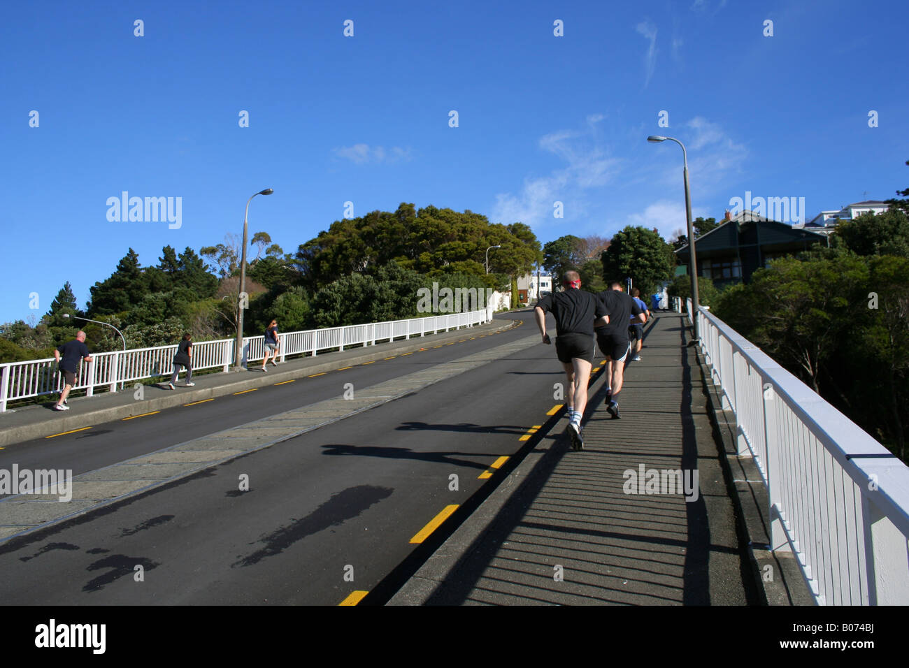 Jogger laufen bis steil geneigten Straßenüberführung. Stockfoto