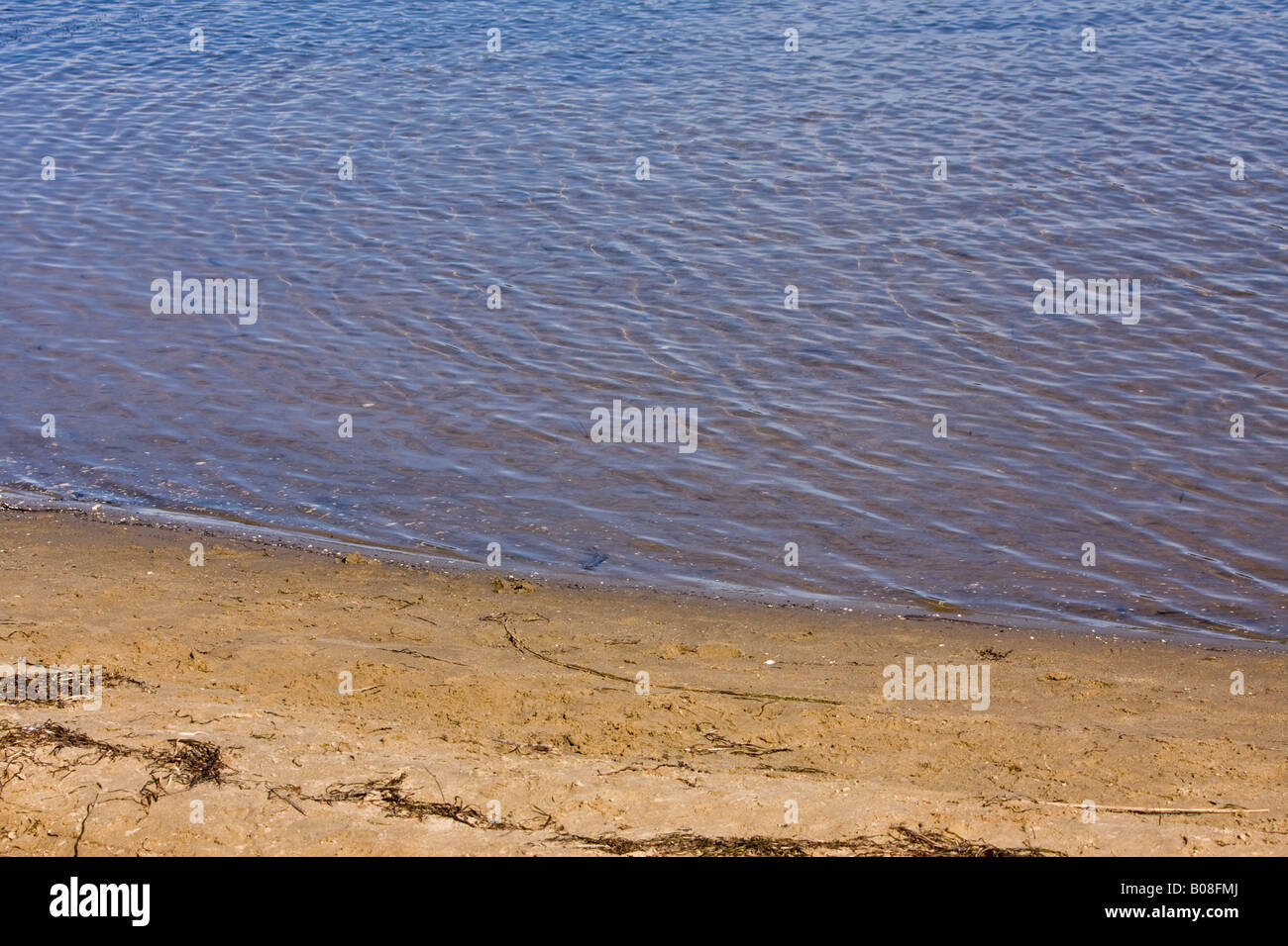 Kleine Wellen sandige Seeufer Stockfoto