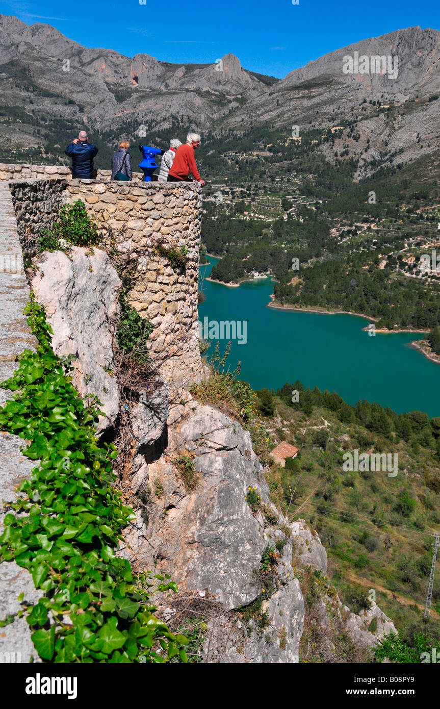 Touristen genießen den Blick auf Berge und Reservoir Damm vom Castell de Guadalest, Guadalest, Costa Blanca, Spanien Stockfoto