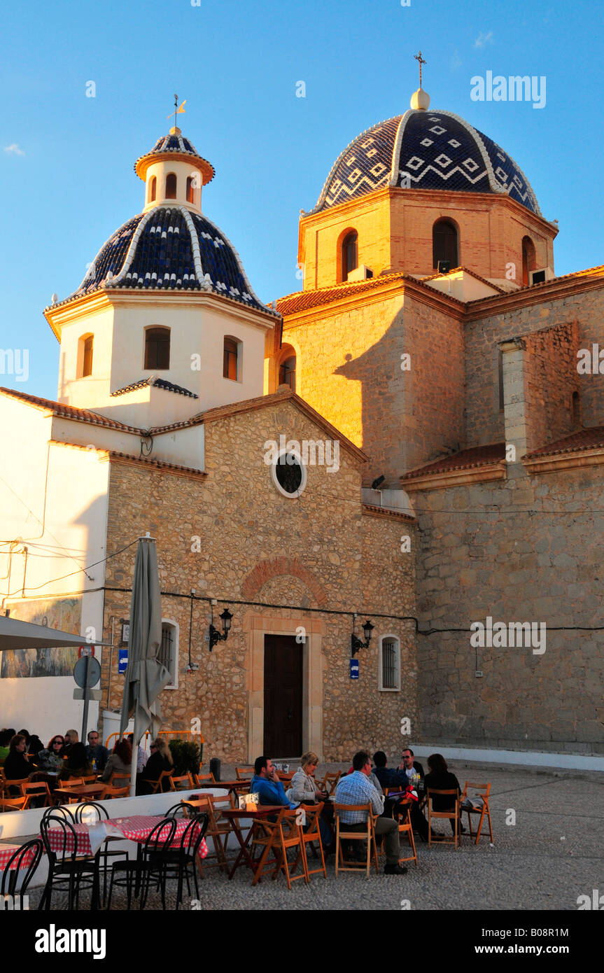 Touristen sitzen an Tischen Café vor den beiden Kuppeln der Iglesia de Nuestra Señora del Consuelo Kirche, Altea Stockfoto