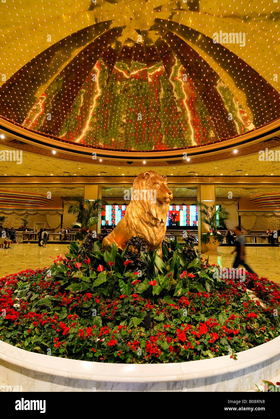 Statue eines goldenen Löwen, umgeben von roten Blumen unter einer goldenen Kuppel in der Lobby des MGM Grand Hotel and Casino, Las Vegas Stockfoto