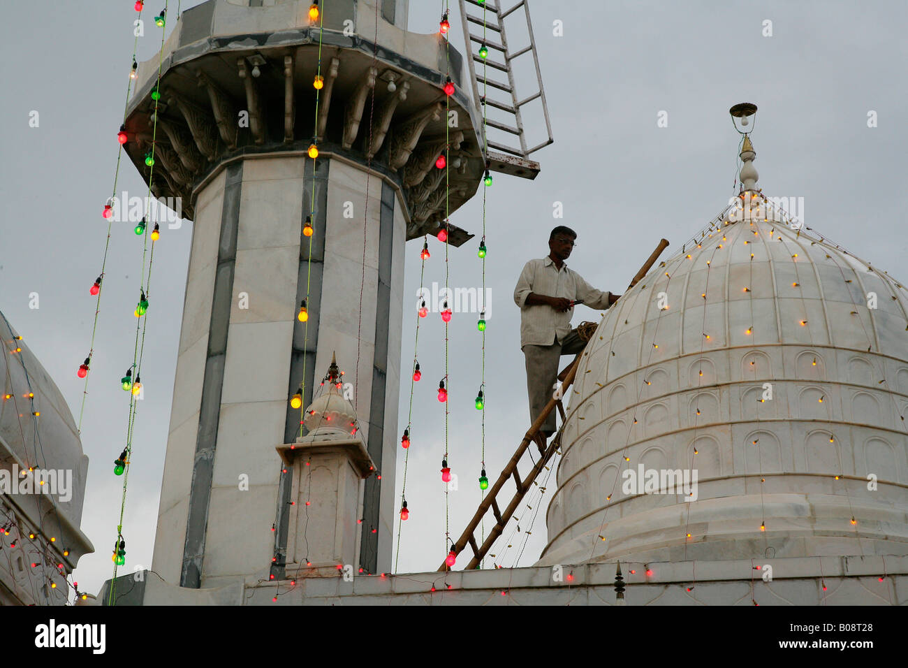 Mann, die Einrichtung von Leuchten für ein Festival in einem Sufi-Schrein, Bareilly, Uttar Pradesh, Indien, Asien Stockfoto
