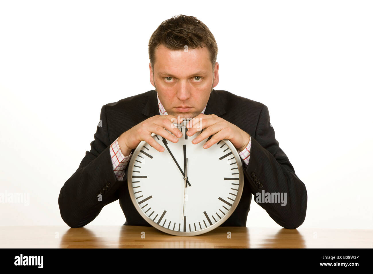 40 Jahre alte Geschäftsmann stützte sich auf eine Uhr, die Zeit ist 5 bis 12 Stockfoto