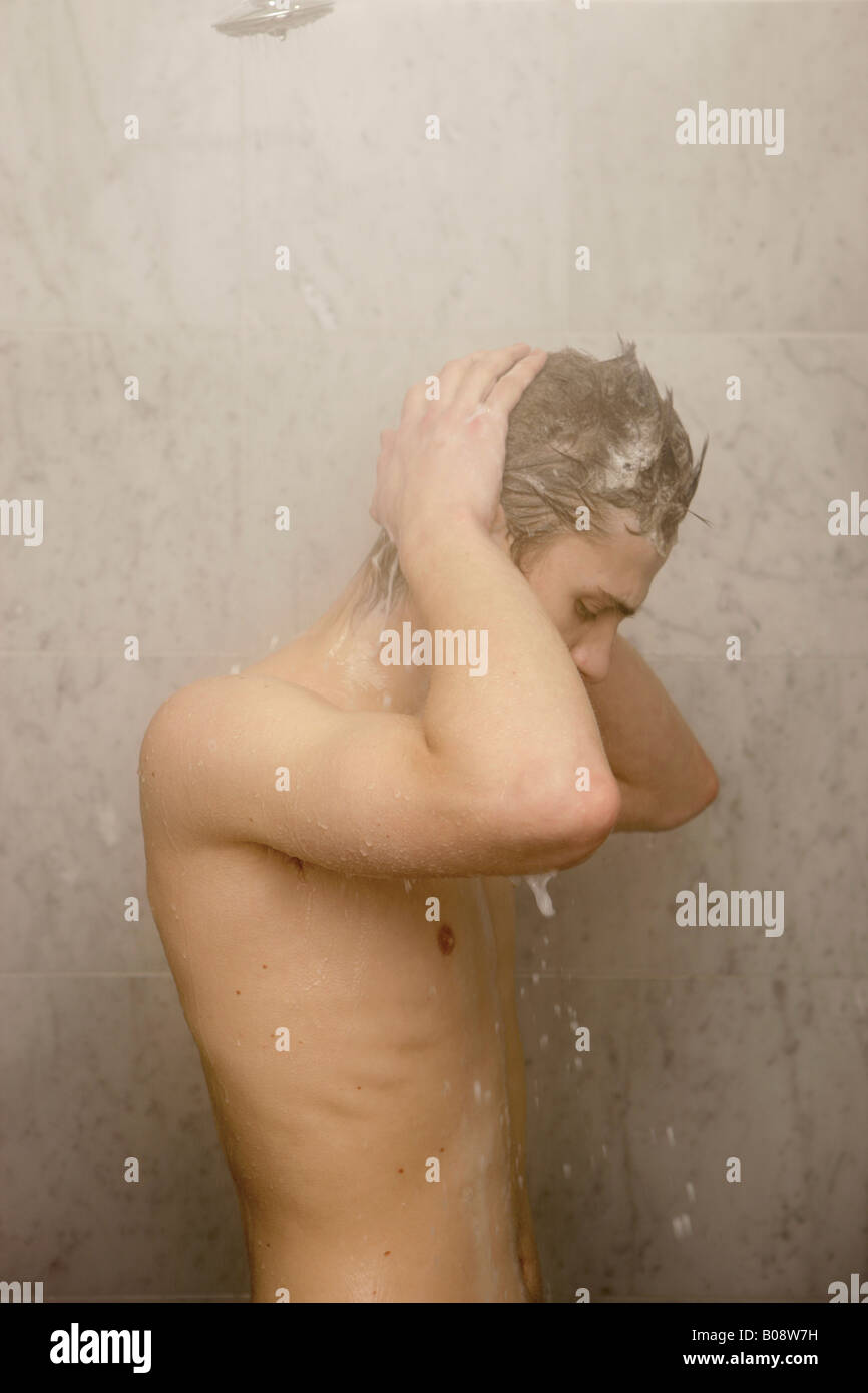 Junger Mann unter der Dusche Stockfoto
