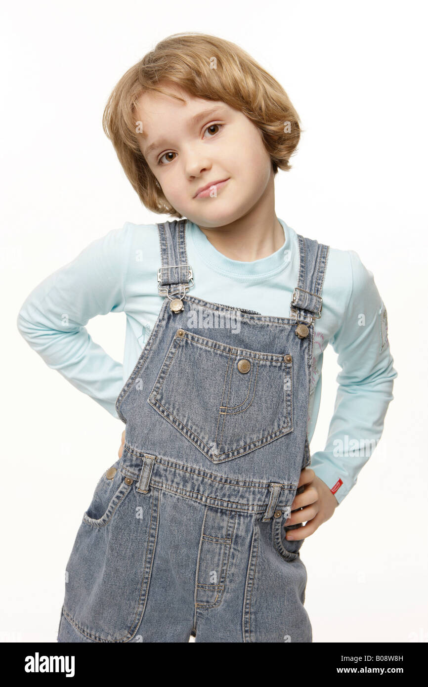 Dunkel-Blonde, 8 jährige Mädchen trägt eine Jeans insgesamt Kleid Stockfoto