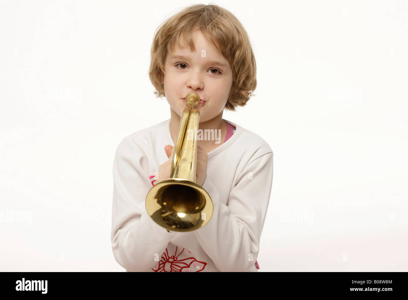 Dunkel-Blonde, 8 jährige Mädchen spielt Trompete Stockfoto