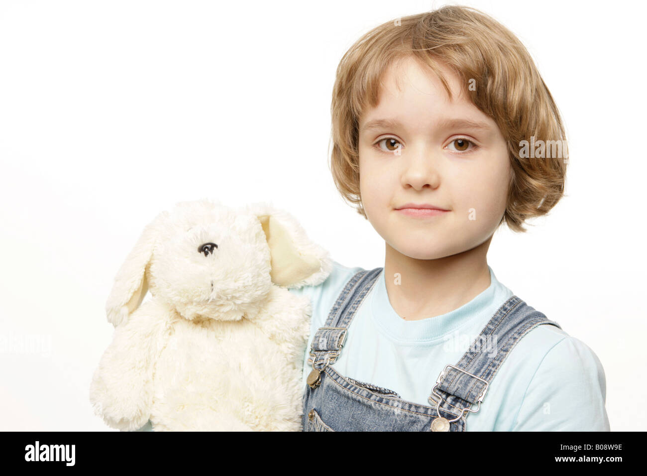 Dunkel-Blonde 8 Jahre altes Mädchen hält ein Tier, Plüsch Stofftier Stockfoto