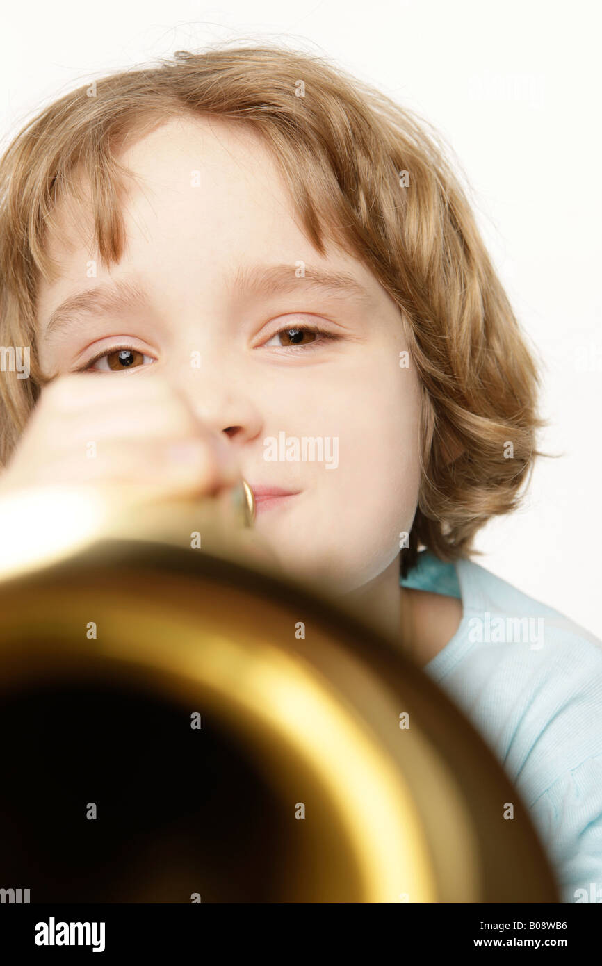 8 Jahre altes Mädchen mit roten Haaren spielt Trompete Stockfoto