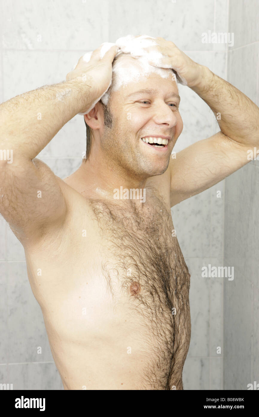 Behaarte Mann, Duschen, Haare waschen, lachen Stockfoto