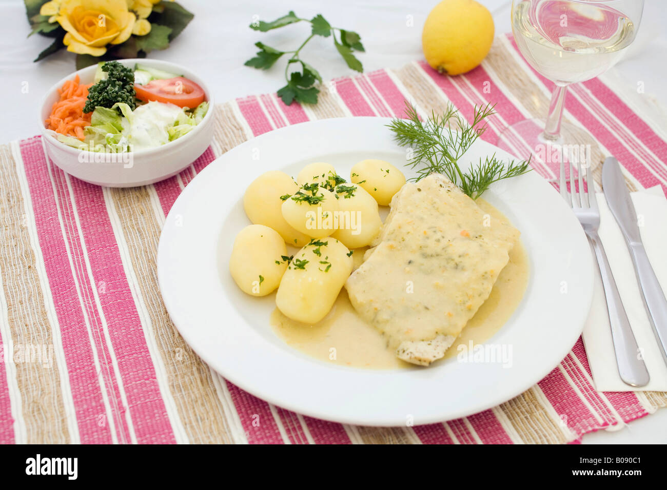 Gedünstetes Lachsfilet mit Senfsauce, Salzkartoffeln und gemischtem Salat Stockfoto