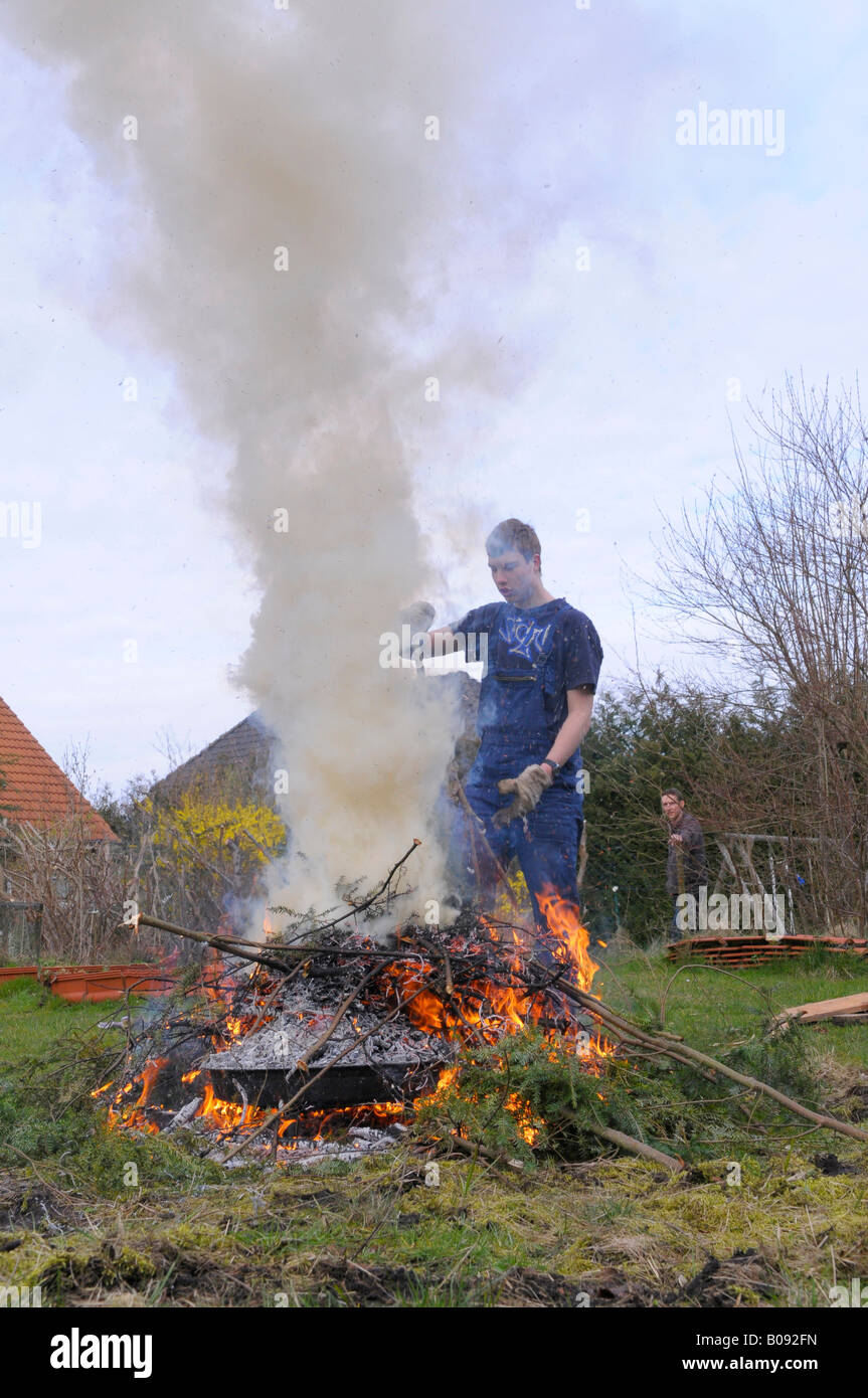 Teenager brennende Gartenabfälle in einem Hof zwar Nachbarn auf, sieht die Mühe Stockfoto