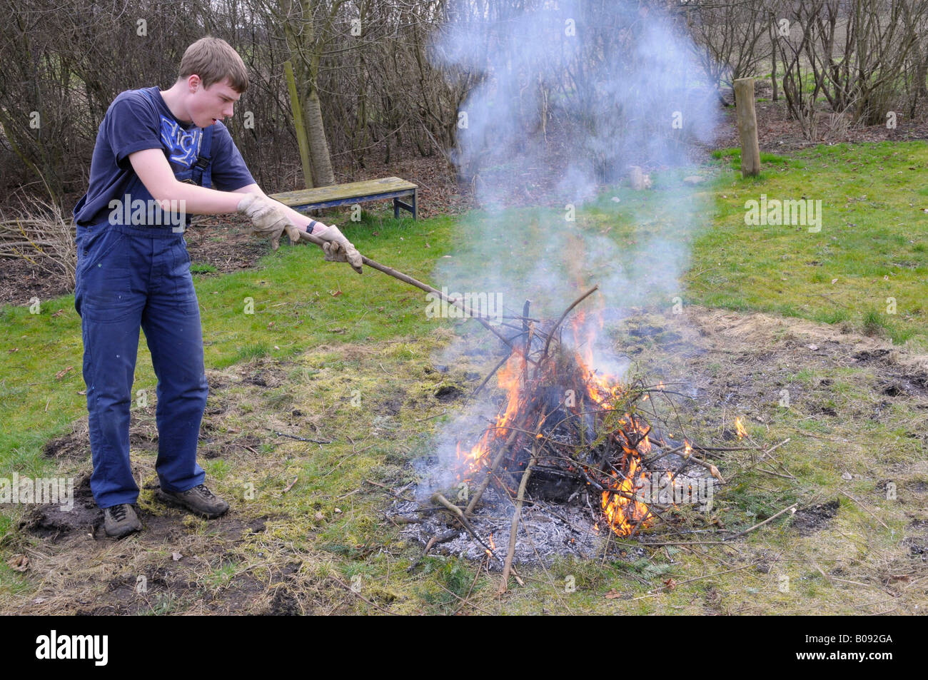 Teenager verbrennen von Gartenabfällen in einem Hof Stockfoto