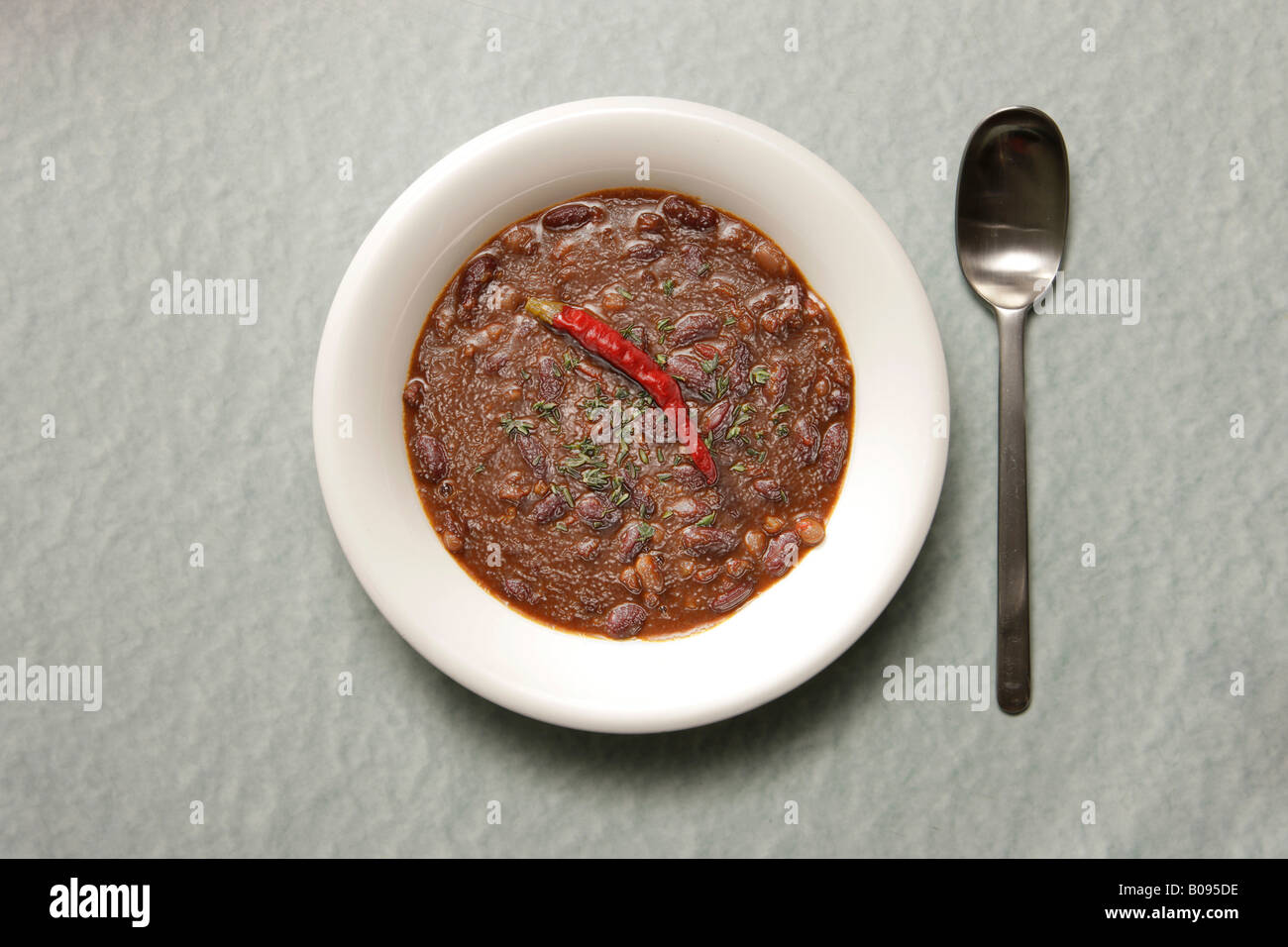 Löffel neben einen Teller mit veralteten Chili Con carne Stockfoto
