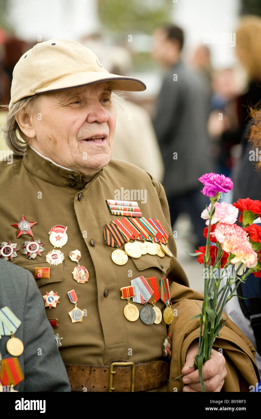 Rote-Armee-Veteran in Uniform und mit Medaillen tragen Blumen am Tag des Sieges im Park des Sieges, Moskau, Russland Stockfoto