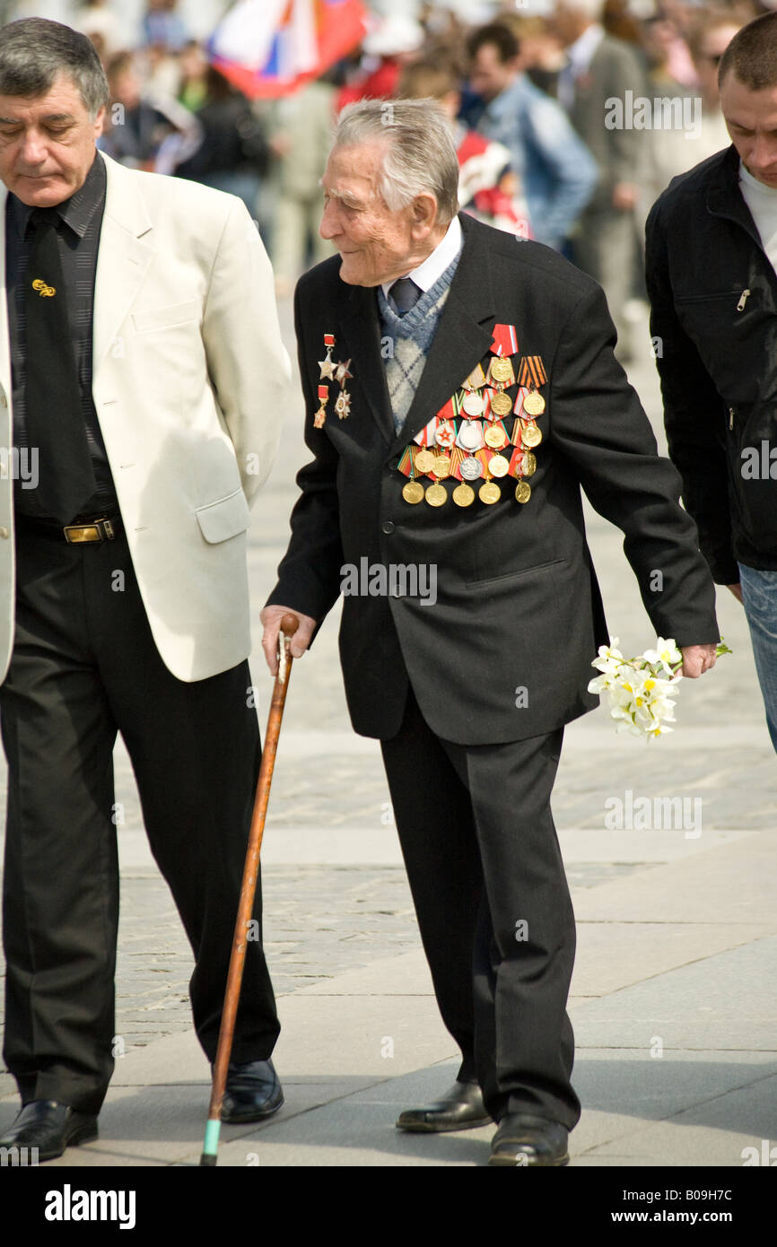 Rote-Armee-Veteran mit Medaillen tragen Blumen am Tag des Sieges im Park des Sieges, Moskau, Russland Stockfoto