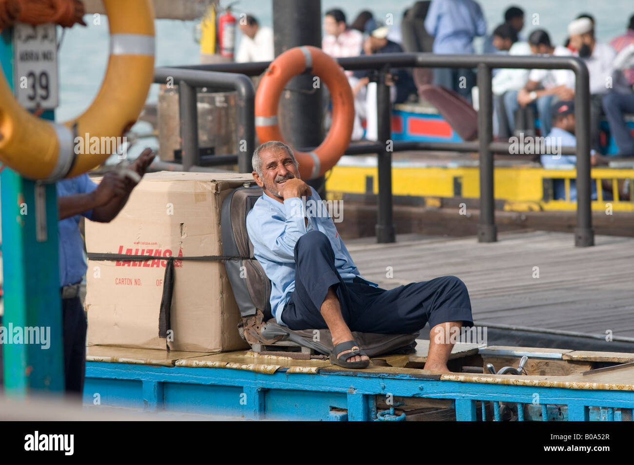 Dubai, Vereinigte Arabische Emirate (VAE). Der Eigentümer eines Abra (Wassertaxi) warten auf Passagiere am Dubai Creek. Stockfoto