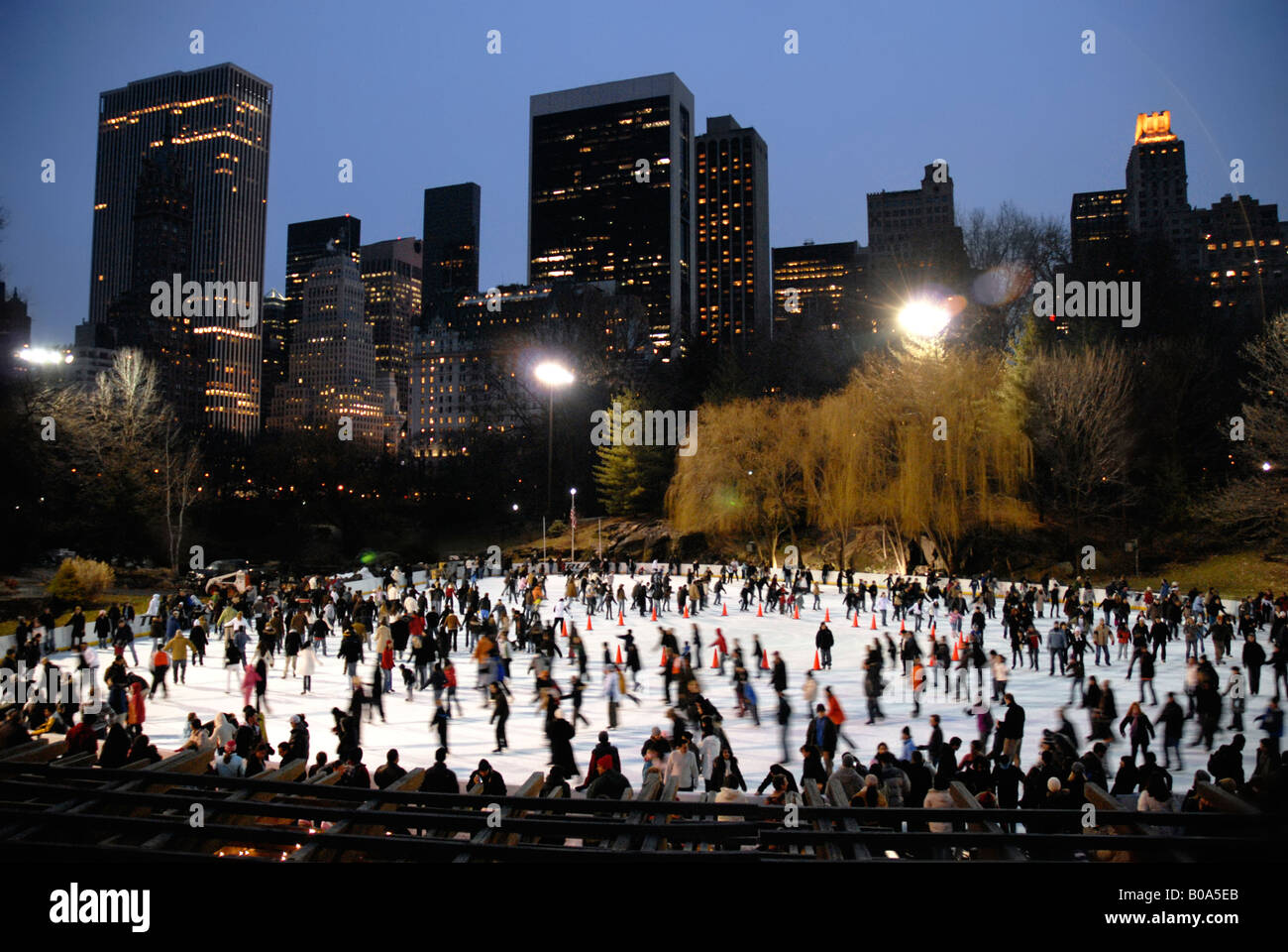 Eislaufen im Central Park bei Nacht im Winter Manhattan Skyline im Hintergrund New York USA Stockfoto