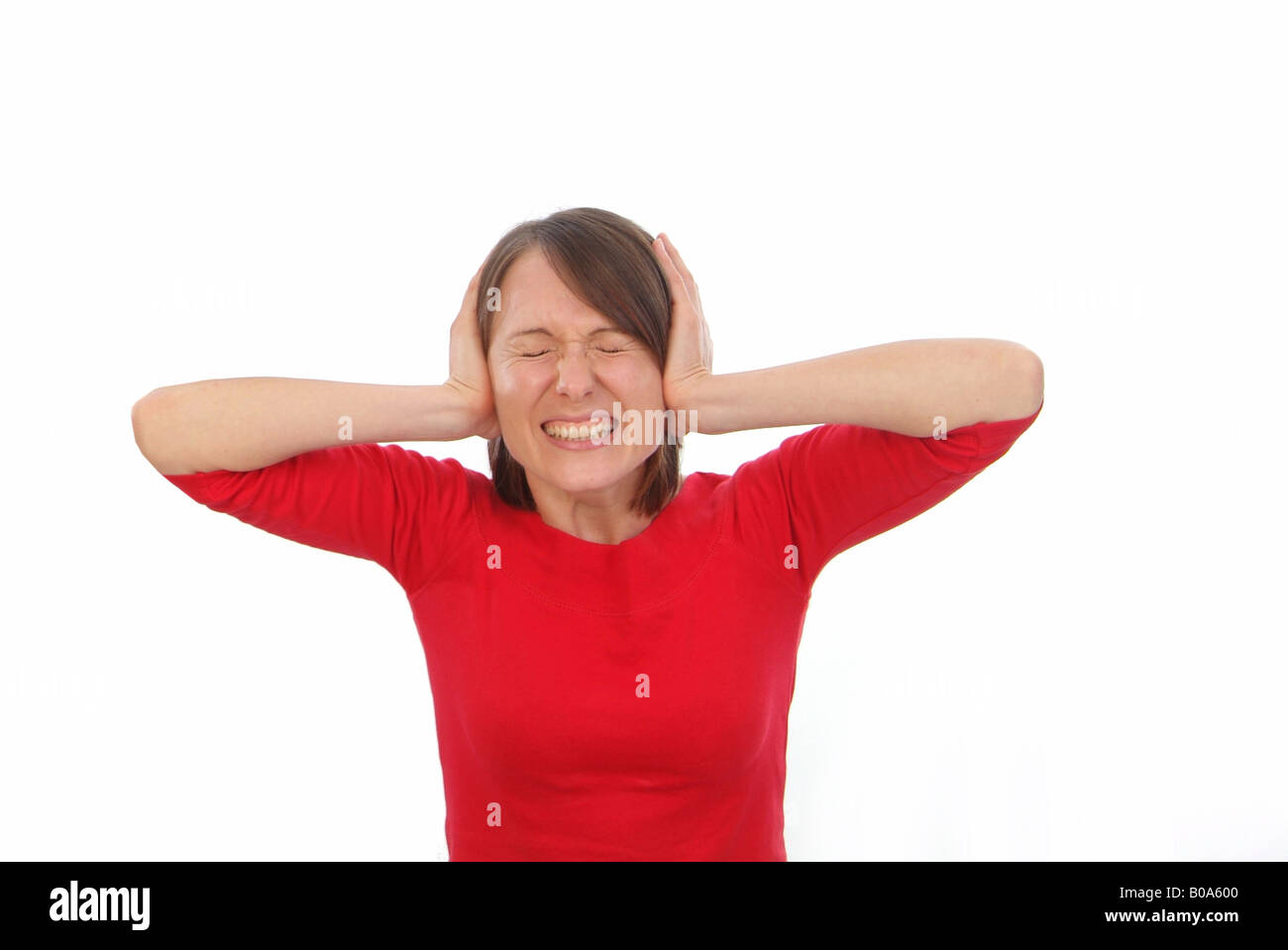 Frau im roten Pullover hält Ohren geschlossen Stockfoto