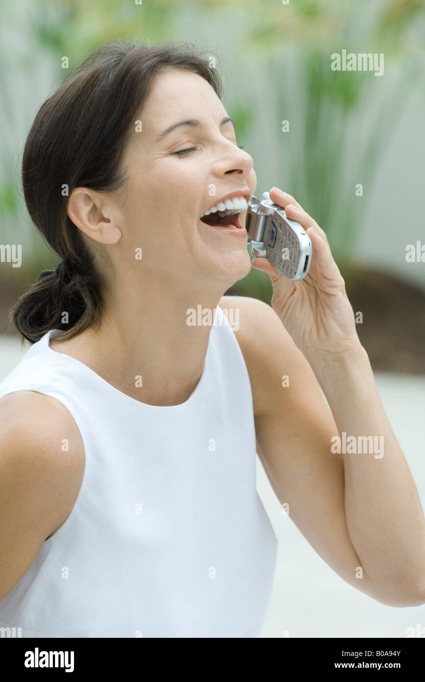 Frau mit Handy, lachen, Augen geschlossen Stockfoto
