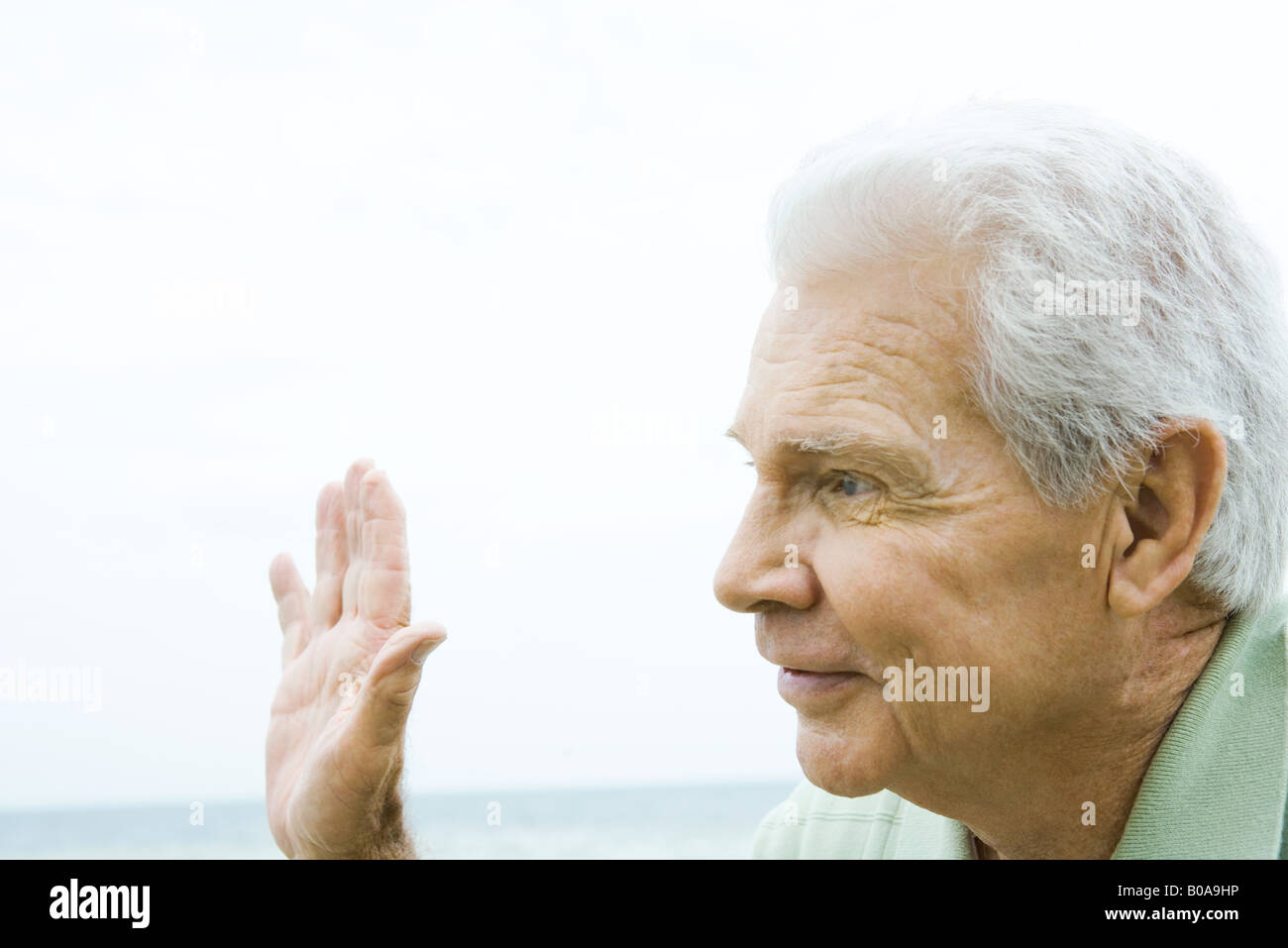 Senior woman winken Hand, smiling, Seitenansicht Stockfoto