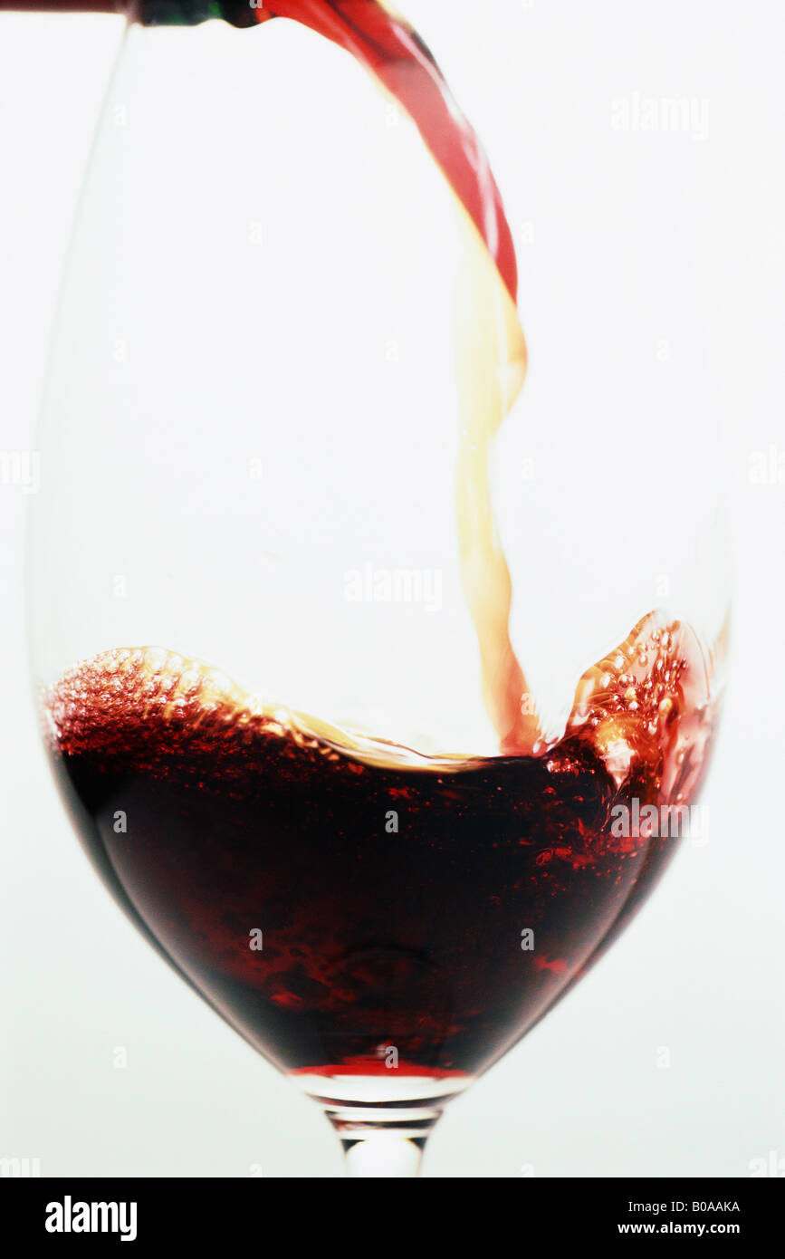 Rotwein wird in Weinglas gegossen Stockfoto
