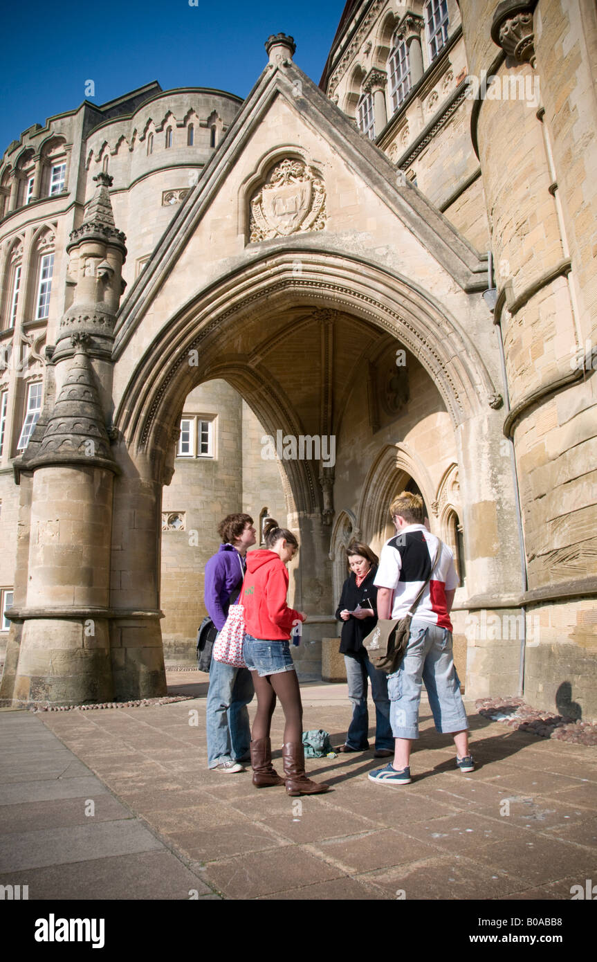 Gruppe von vier Studenten außerhalb des Old College Aberystwyth University Wales UK - ein viktorianischen gotischen Sandstein Gebäude Stockfoto
