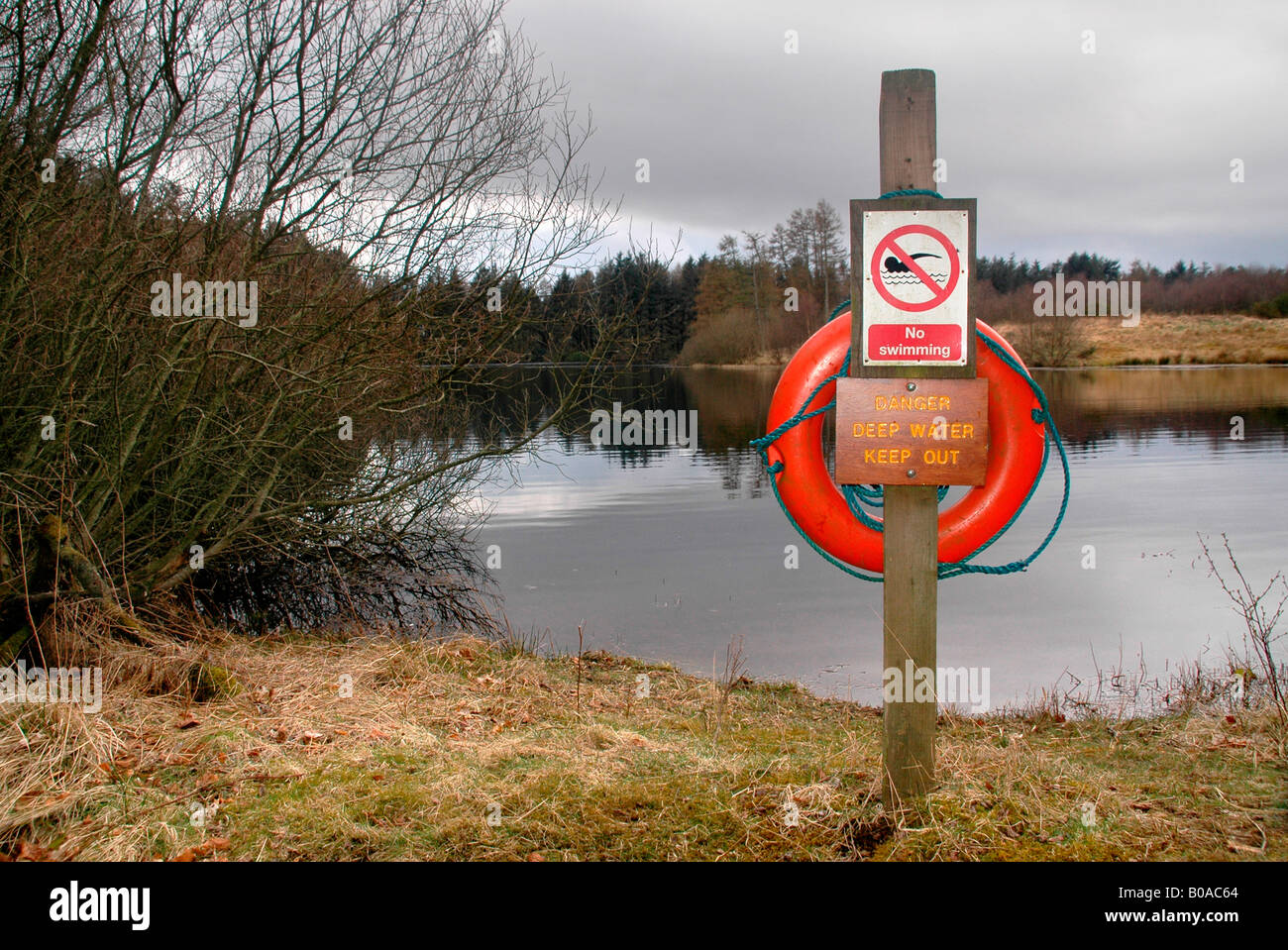 Ein Warnschild mit einem Rettungsring, Warnung vor den Gefahren des Tiefenwassers und schwimmen zu verbieten. Stockfoto