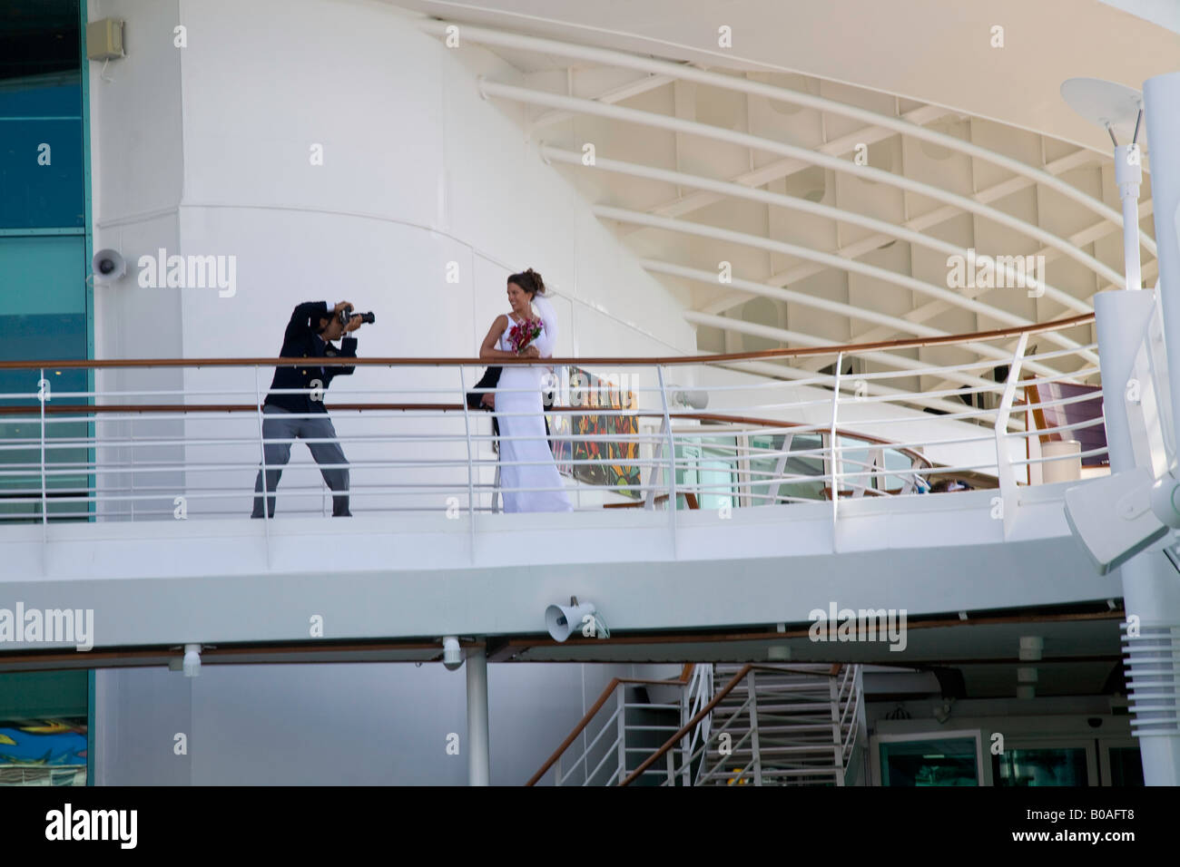 Hochzeitsfotograf fotografiert eine Braut auf dem Deck Kreuzfahrtschiff der "Mariner of the Seas" Stockfoto