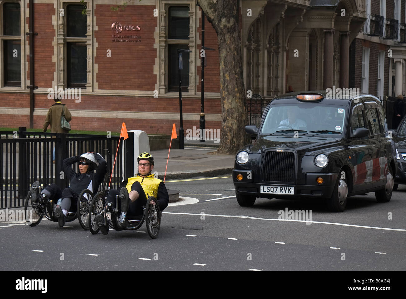 ein paar Radfahrer mit Liege-Fahrräder warten an einer Ampel mit London schwarz Kabine hinter Ihnen Stockfoto