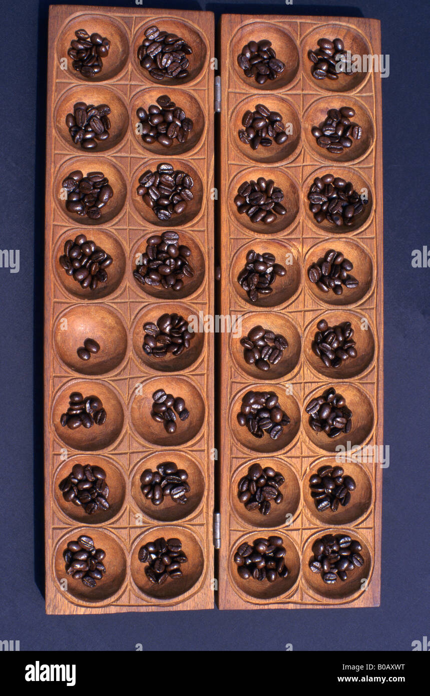 Omweso oder Bao aus Holz Brettspiel gespielt in Afrika. Seine Strategie mit  Kaffeebohnen, Samen oder Murmeln gespielt Stockfotografie - Alamy