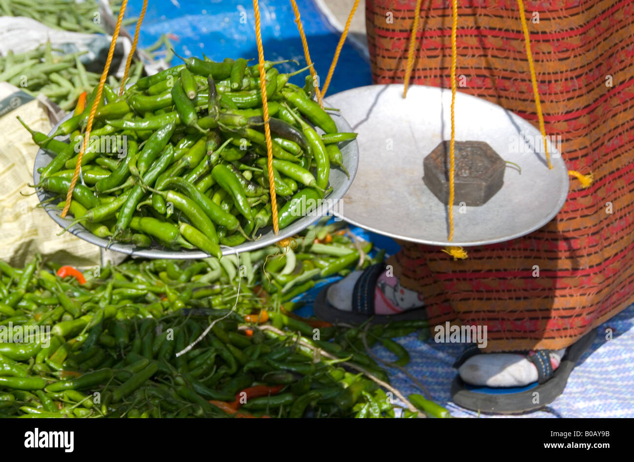Mit einem Gewicht von grüne Chilischoten auf dem Sonntagsmarkt Paro, Bhutan Stockfoto