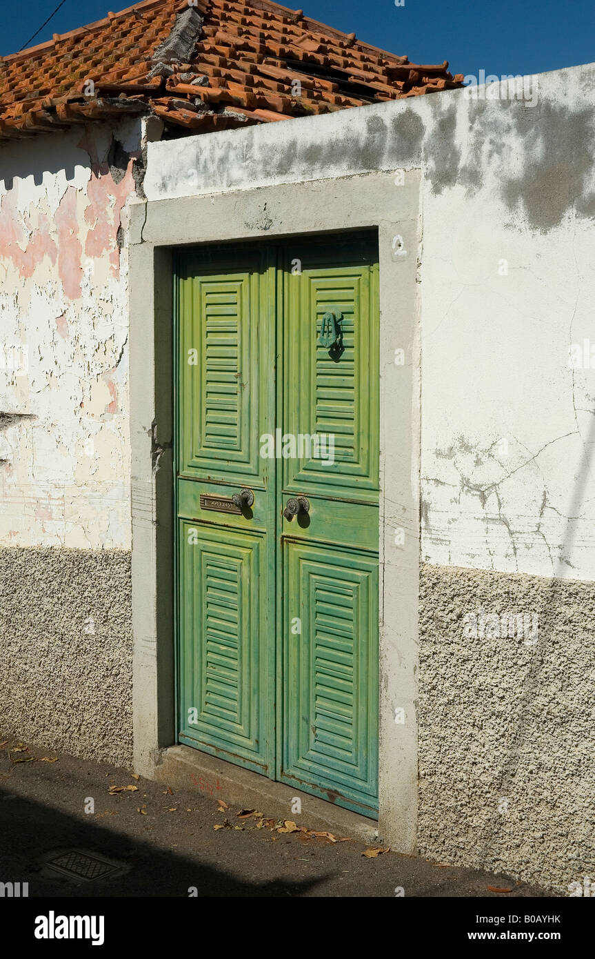 Alte grüne Metalltüren inmitten einer Betonwand Stockfoto