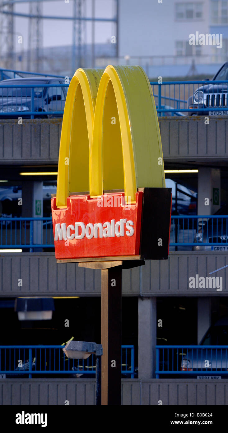 Die goldenen Bögen von der Fast-Food-Kette McDonalds Satz gegen eine urbane Landschaft bei Sonnenuntergang. Bild von Jim Holden. Stockfoto