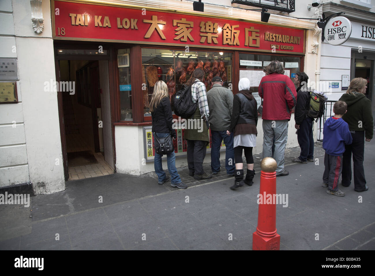 Menschen auf der Suche auf Speisekarte außerhalb Anzeige Fenster Chinatown, Soho, London, England Stockfoto