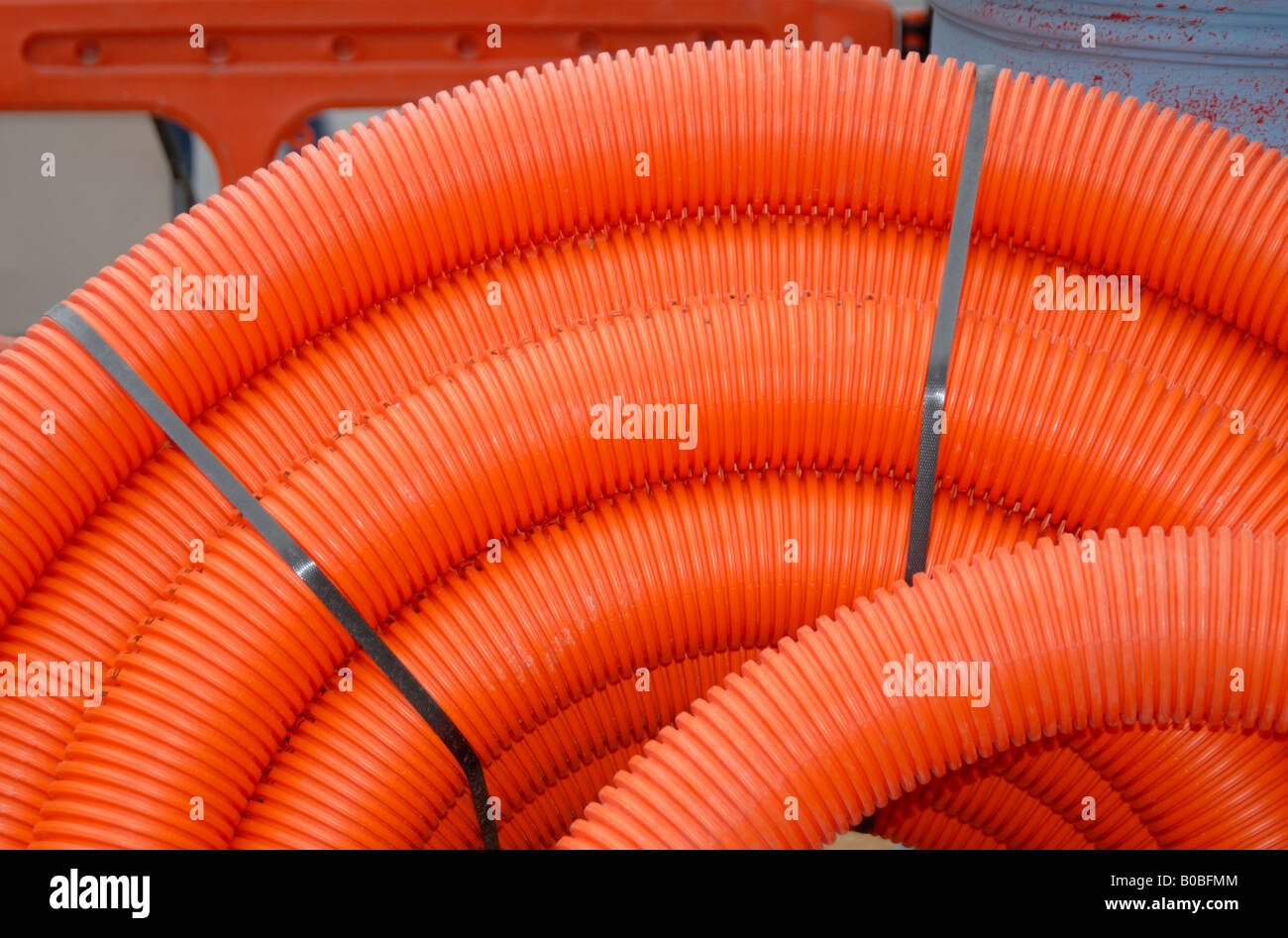 Gewickelten Orange gewellte Kunststoffrohre für Elektrokabel, London, England, Großbritannien, Vereinigtes Königreich, Europa zu begraben. Stockfoto
