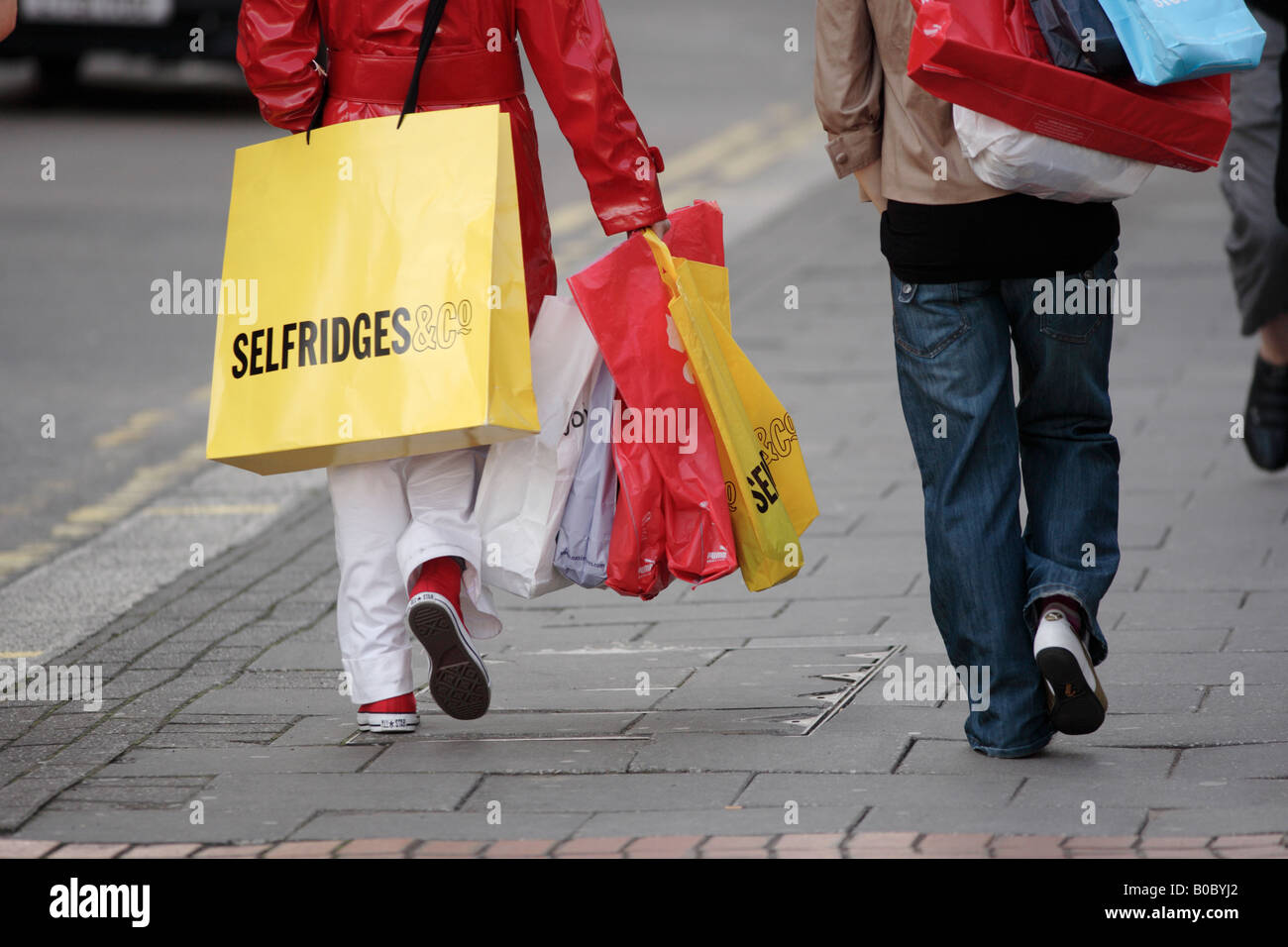 Zwei junge Frauen, die die shopping Tragetaschen in Birmingham City centre UK Stockfoto
