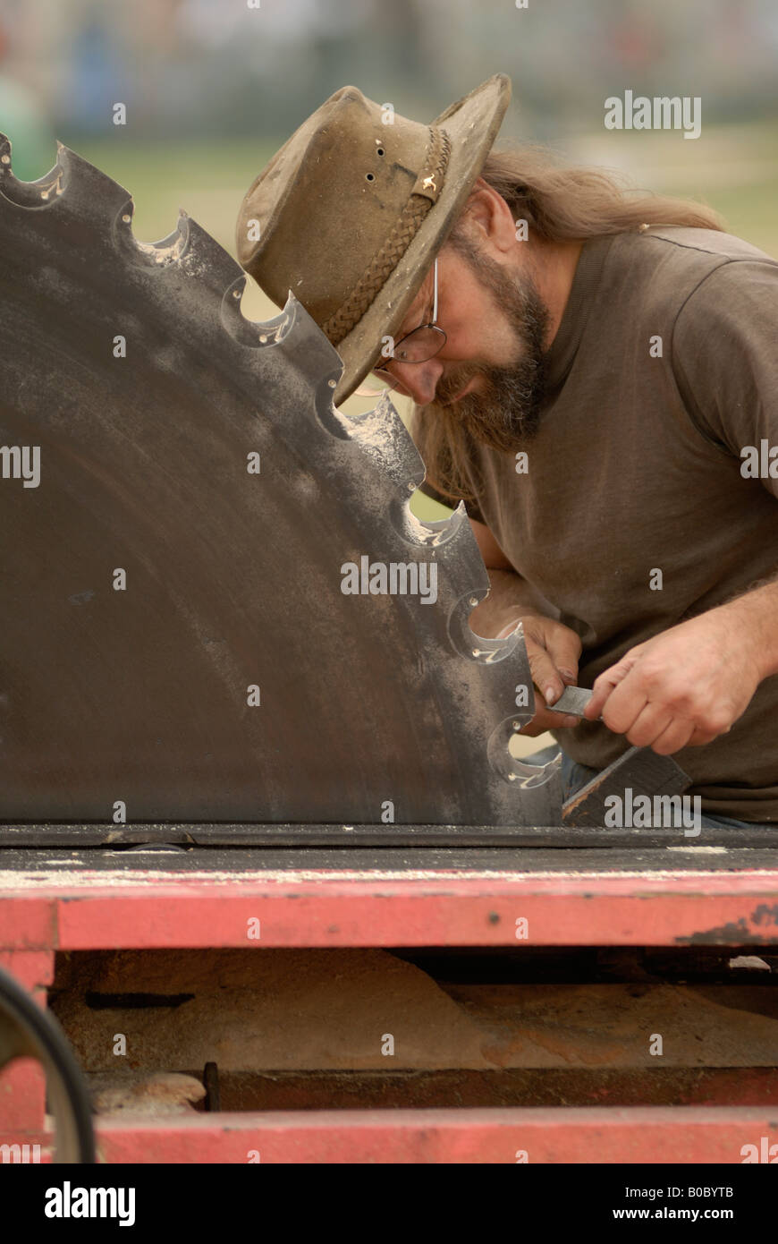 Ein Mann schärft die Zähne eine große kreisförmige Holz Sägeblatt Stockfoto