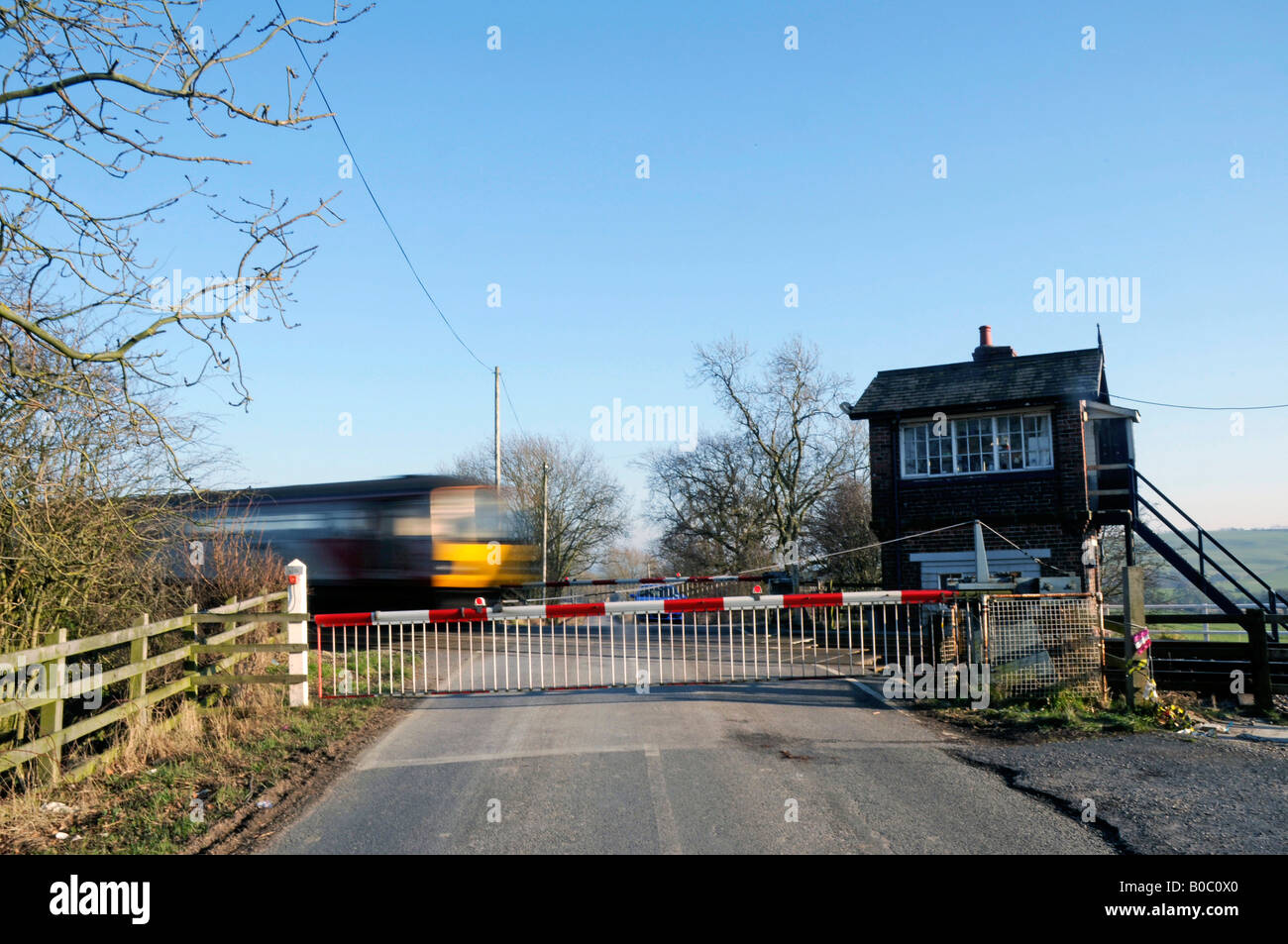 Trainieren Sie, nähert sich die Barriere Eisenbahn überqueren, North Yorkshire, England Stockfoto
