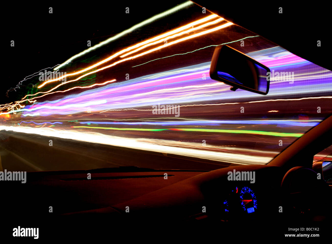 Straßenbeleuchtung, Verkehrs- und Ladenfronten produzieren atemberaubende Lichtspuren als die Kamera Streifen durch in einem schnell fahrenden Auto Stockfoto