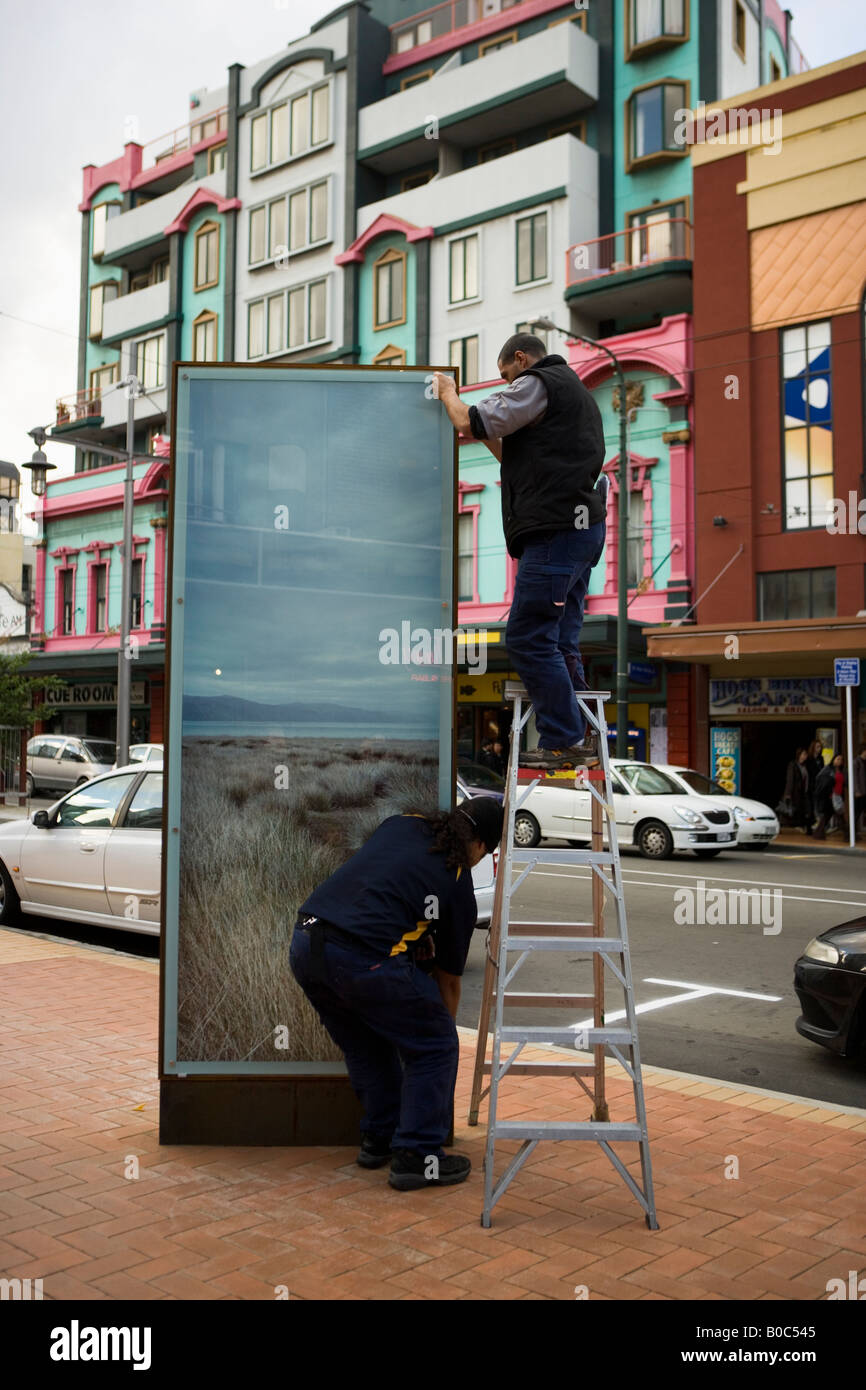 Zwei Männer ordnen Plakat Werbung auf Courtney Place, Wellington, Neuseeland Stockfoto