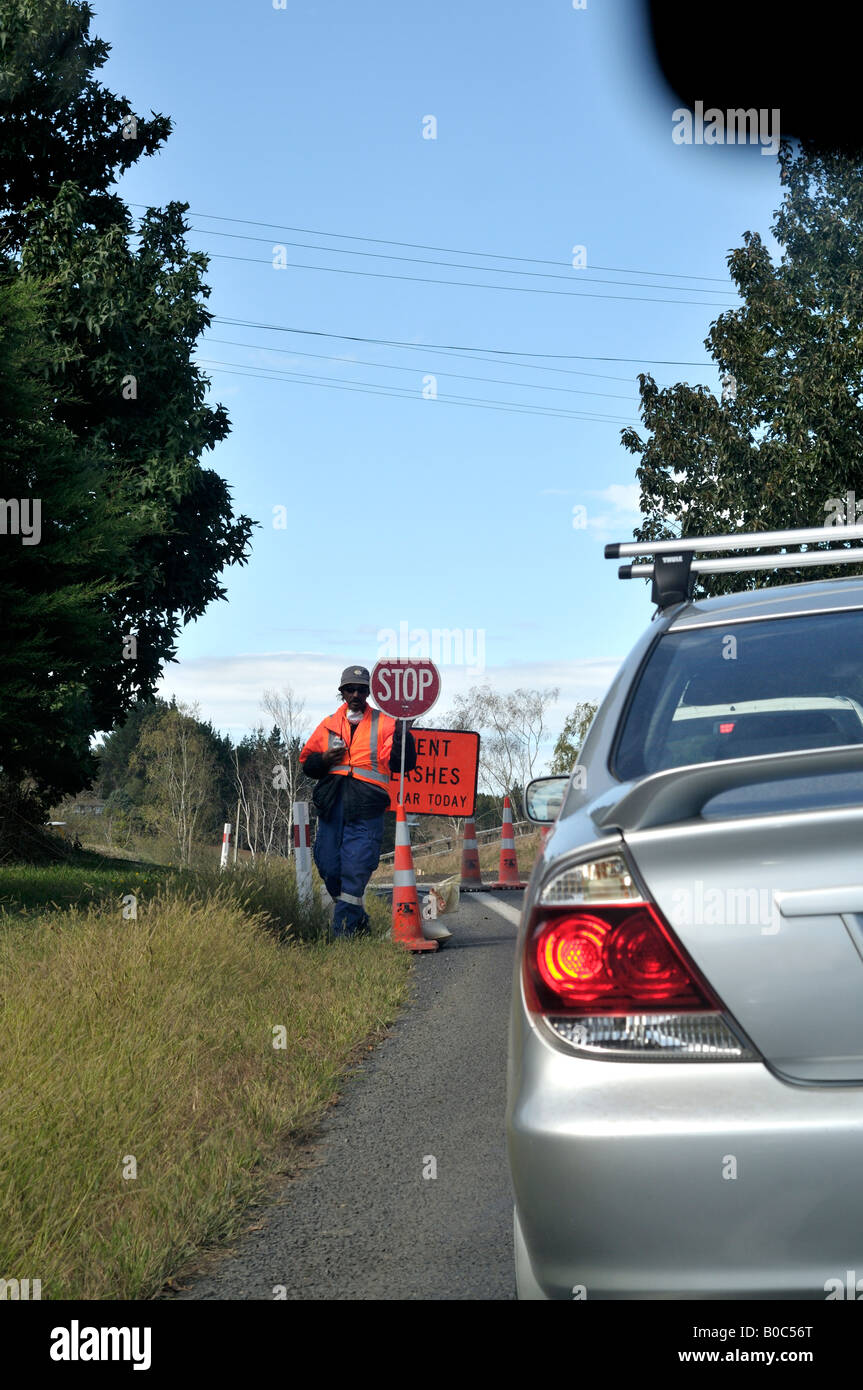 Mann, sitzend auf Baustellen mit Stop-Schild Stockfoto