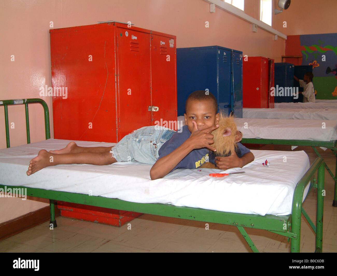 Ein behinderter junge, in seinem Bett in der Helen Bischof Heimat. Stockfoto
