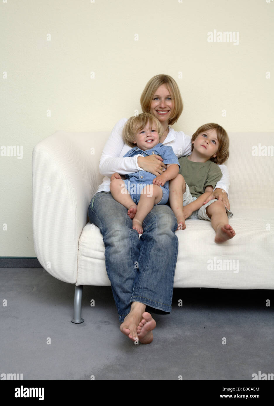 Mutter mit Kinder sitzen auf einem sofa Stockfoto