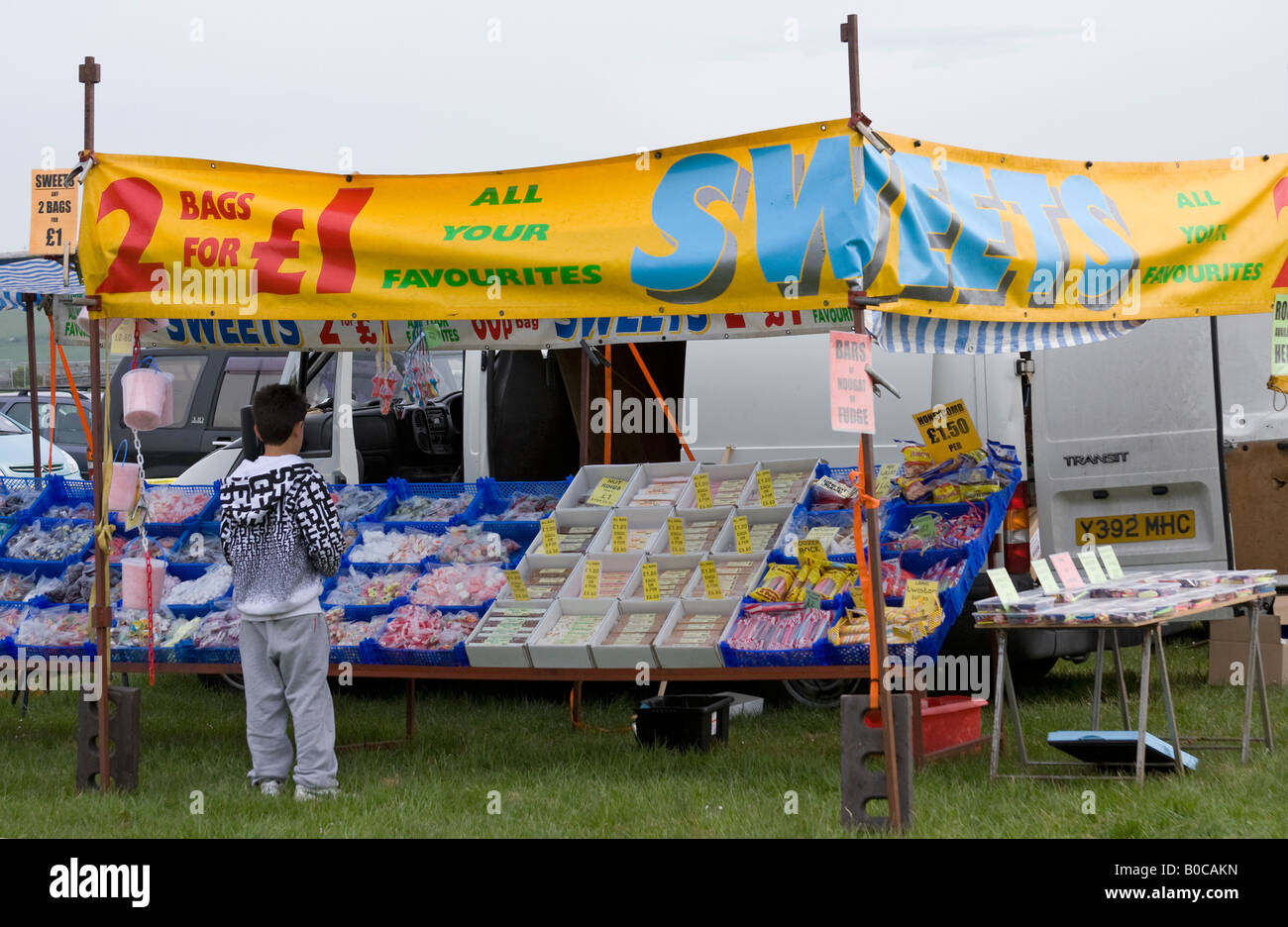 Kleiner Junge Süßigkeiten von süßen Stall im englischen Markt zu kaufen Stockfoto