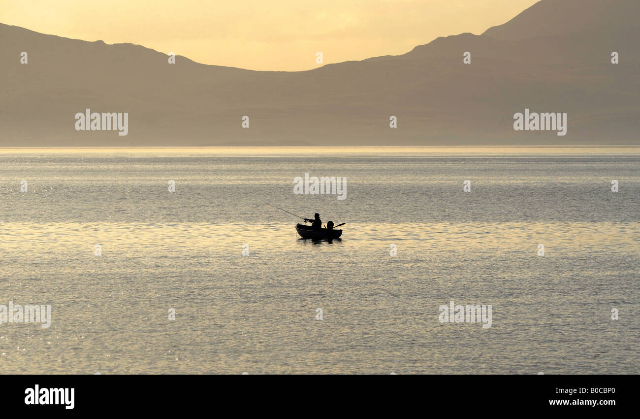 EIN FISCHER GENIEßT EINE LATE-NIGHT-ANGELTOUR IN DER NÄHE VON ISLE OF JURA AN DER SCHOTTISCHEN KÜSTE. Stockfoto