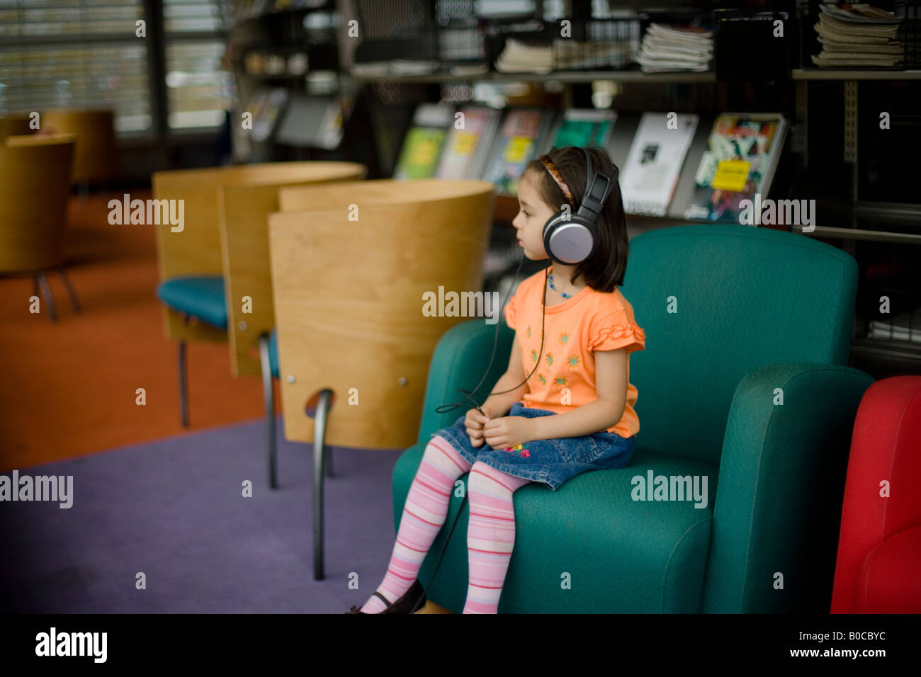 Zentrale Bibliothek Palmerston North New Zealand vier Jahre alten Mädchen hört Radiosendungen über Kopfhörer Stockfoto