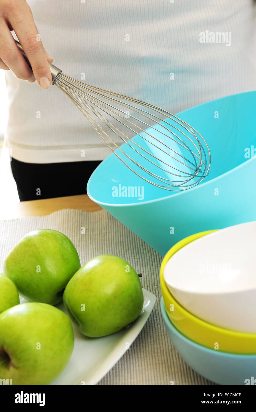 Frau, die Zubereitung von Speisen mit Schneebesen und Schüssel Stockfoto