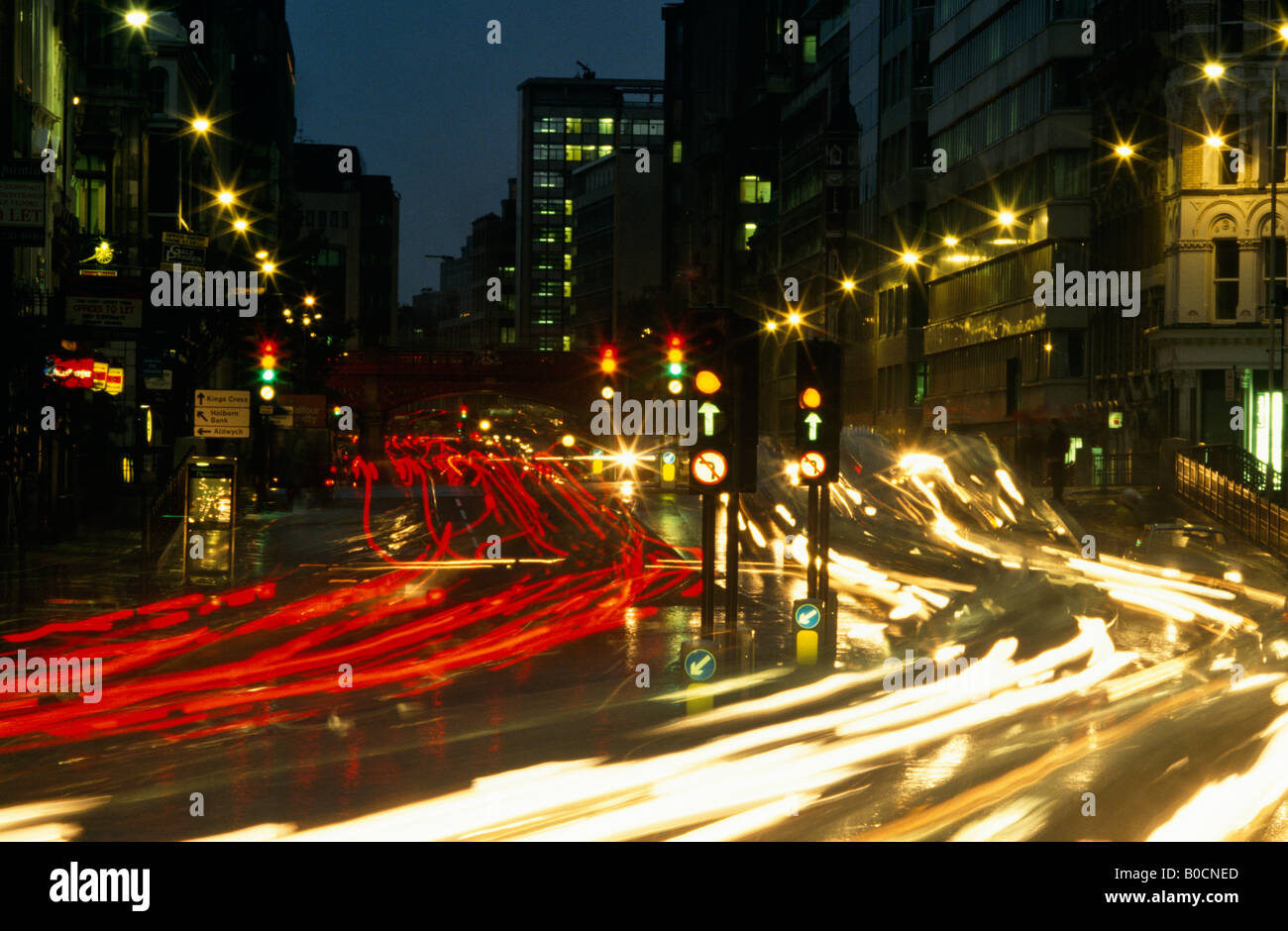 Ampeln, die Unschärfe in der Nacht über die Kreuzung der Farringdon Road und Fleet Street in der City of London Stockfoto