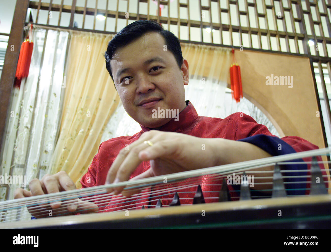 Chinesischer Mann spielen traditionelle Guzheng Musikinstrument Stockfoto
